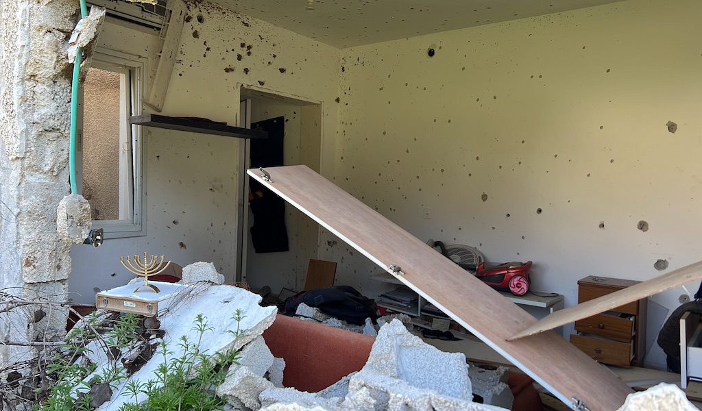 Innenansicht von einem zerstörten Wohnraum in Kfar Aza. Der auf der linken Seite aufgestellte Chanuka-Leuchter bringt etwas Licht und Hoffnung.