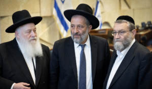 Aryeh Deri, Yitzhak Goldknopf und Moshe Gafni stehen gemeinsam vor israelischen Flaggen in der Knesset.